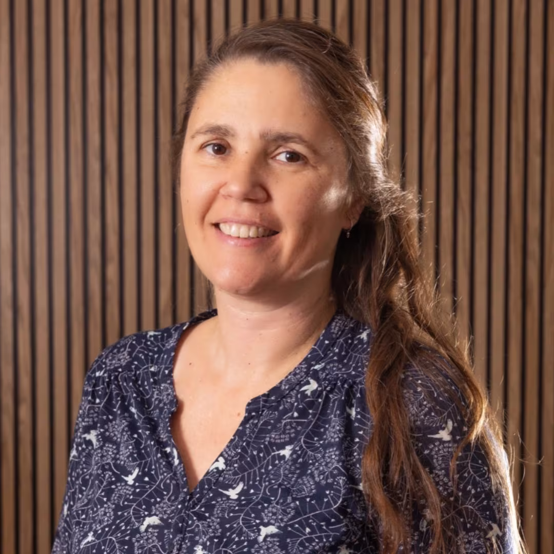 Gemma Guarch smiling in front of a wooden slat wall