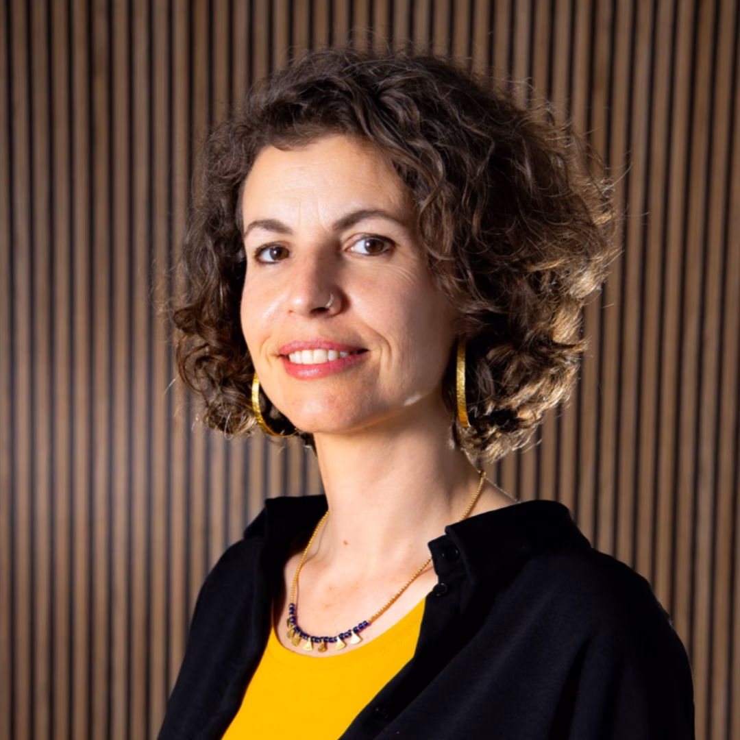 Irene Pérez, art therapist at Clínica Synaptica, wearing gold earrings and a yellow top