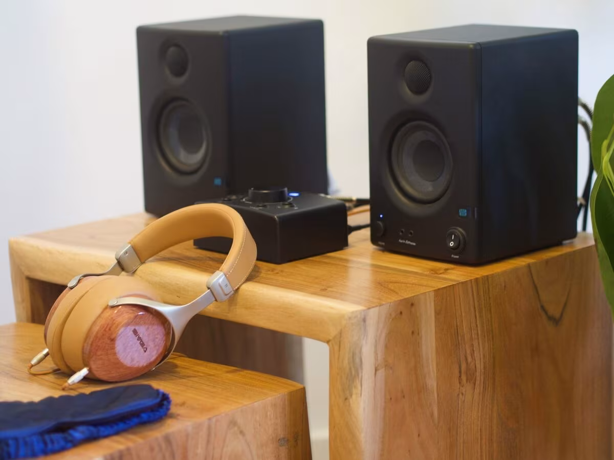 Cuffie, altoparlanti e mascherina su tavoli di legno per la musica nelle sessioni psichedeliche