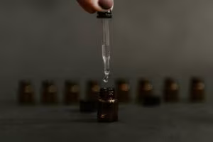 Dropper releasing a drop into an amber glass bottle