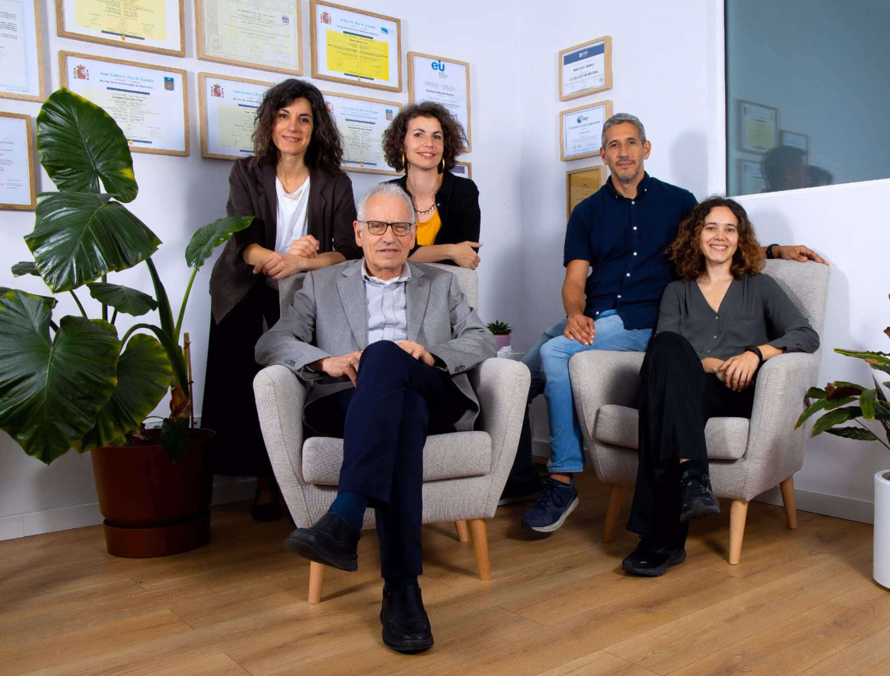 Equipo de Clínica Synaptica posando en la clínica, con diplomas en la pared
