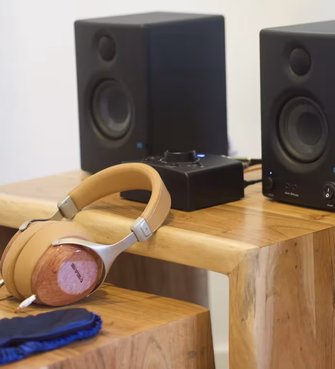 Auriculares y altavoces sobre mesas de madera para musicoterapia
