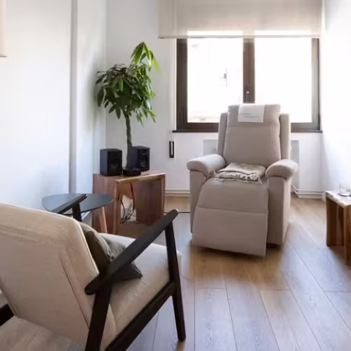 Bright therapy room with a reclining armchair, plant and speakers